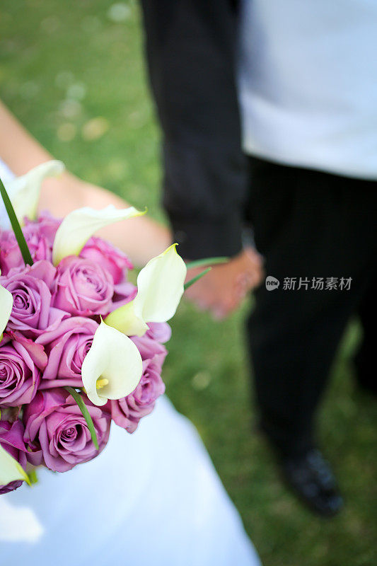 新娘和新郎手牵手捧花束