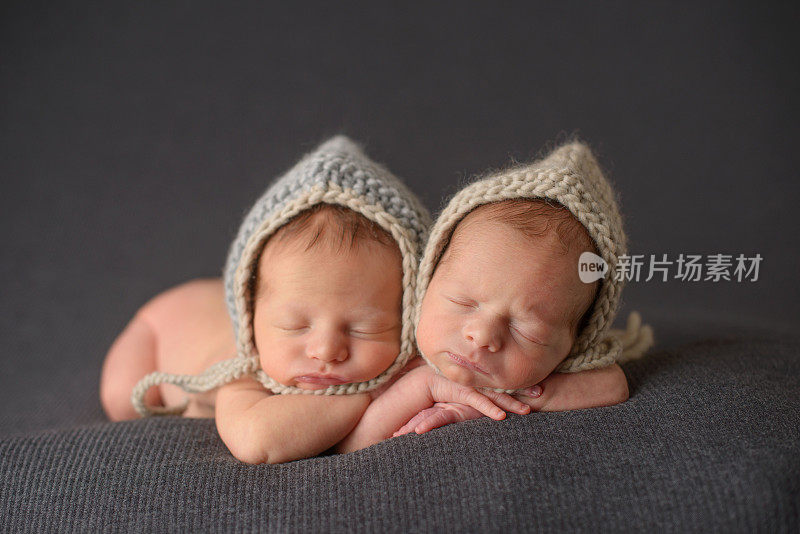 刚出生的双胞胎戴着针织帽睡觉