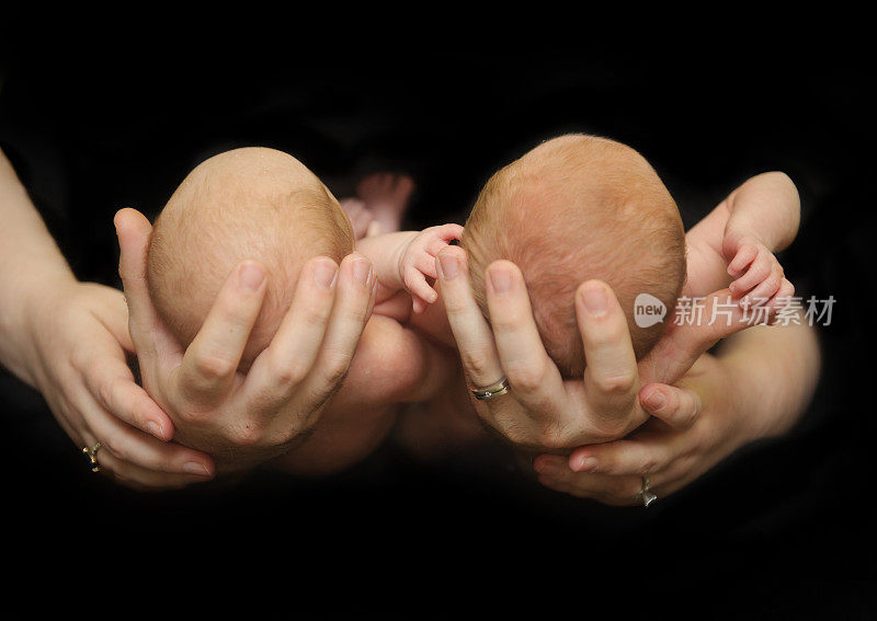 刚出生的双胞胎兄弟在父母的手中