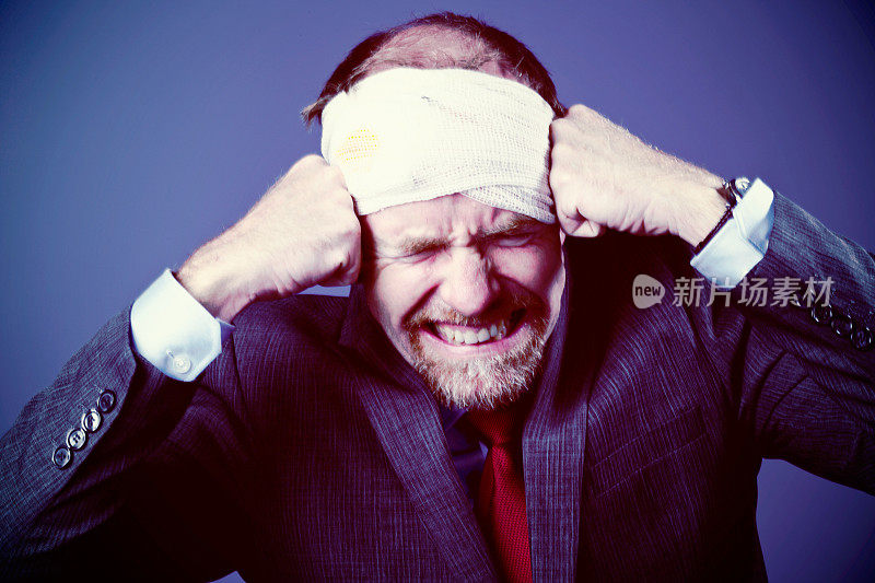 头痛得眼睛发花!一个打着绷带，愁眉苦脸的男人痛苦地紧紧抓住太阳穴