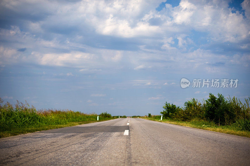 以蓝天白云为背景的乡间小路