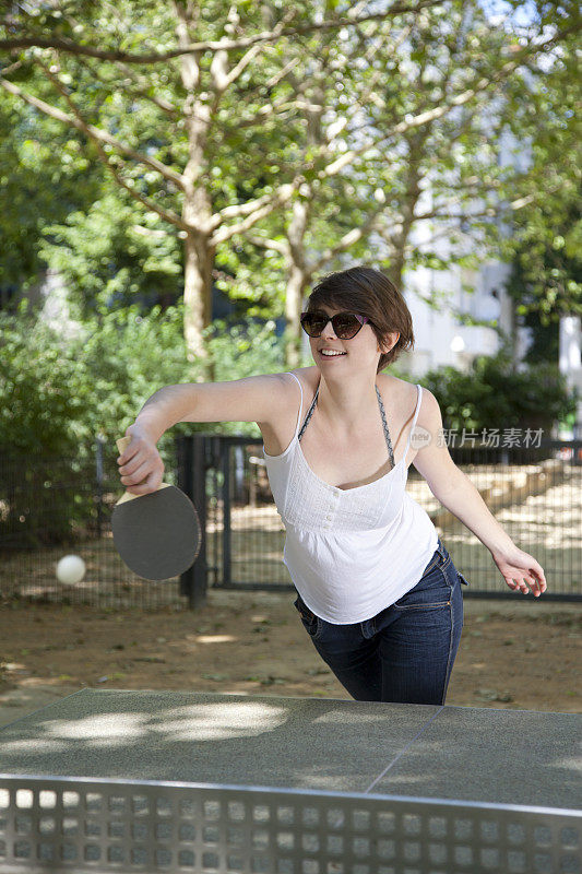 年轻女子在公园里打乒乓球