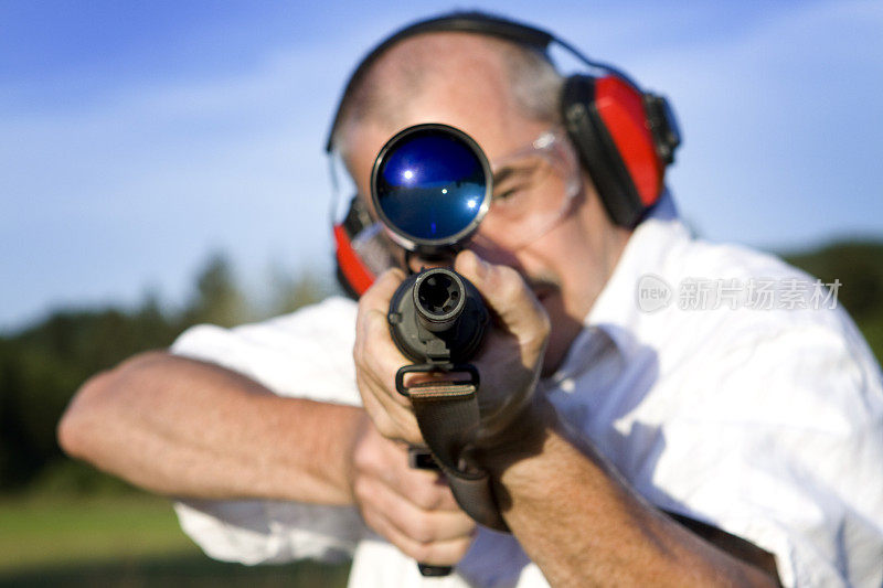 戴着耳罩和护目镜的人是目标射击。