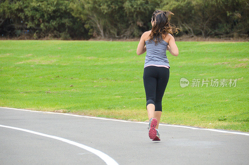 运动健将的年轻女子在跑道上奔跑