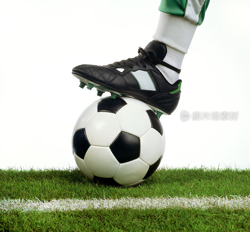 足球在足球运动员鞋下的场地上