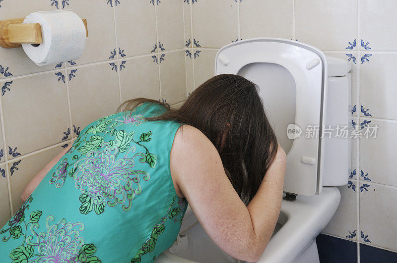 穿着派对礼服的女人在厕所里呕吐