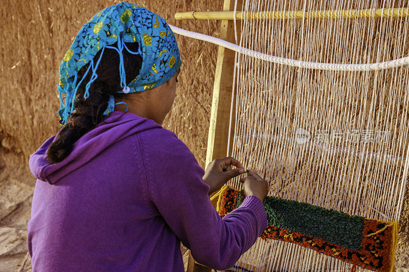 在摩洛哥瓦尔扎扎特编织纺织品的柏柏尔少女