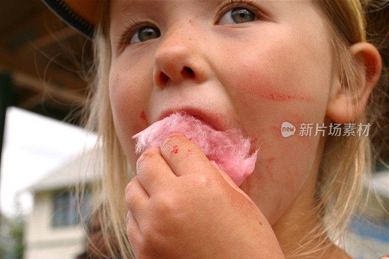 小女孩在吃粉色的棉花糖