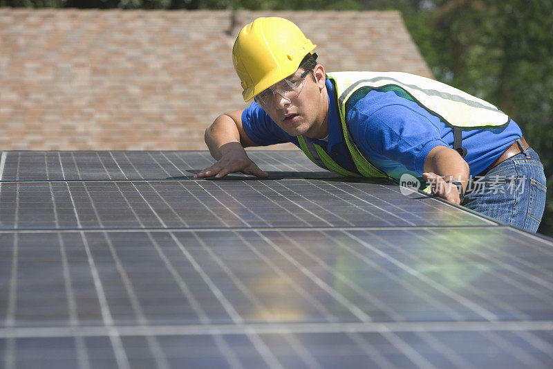 工人正在屋顶上安装太阳能电池板