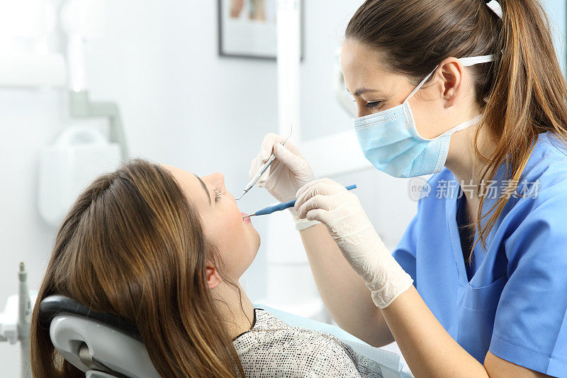 牙科医生在诊所检查病人的牙齿