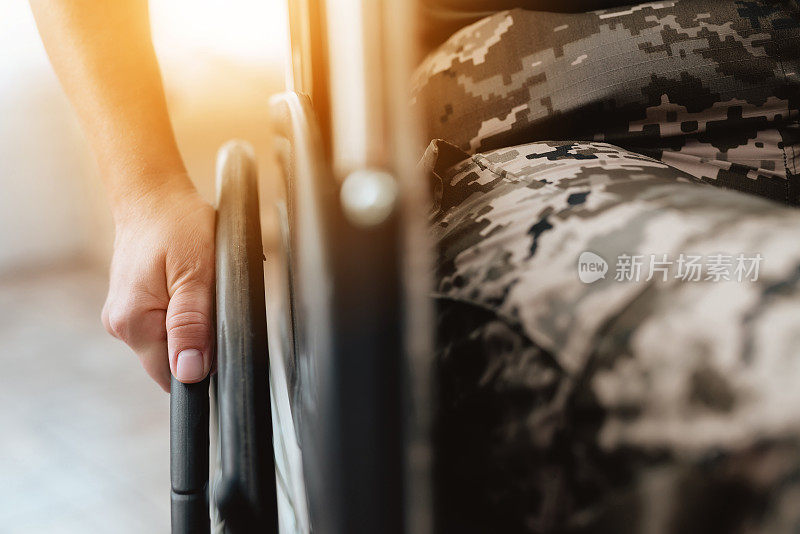 坐轮椅的退伍军人从军队回来。特写照片的老兵妇女在轮椅上。