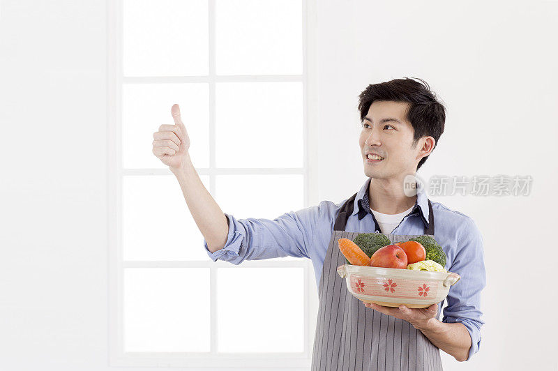 中年男人拿着一大碗的有机蔬菜