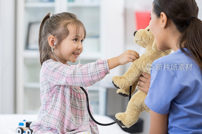 小女孩在看病时检查她的毛绒玩具