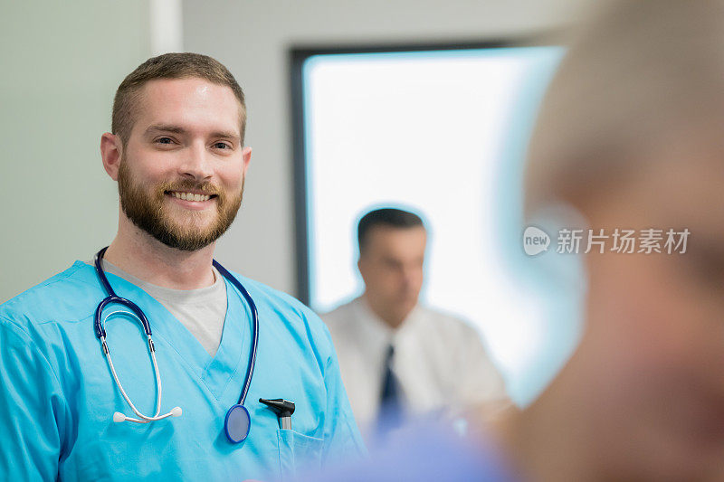 快乐的男医生在医院急诊室对着镜头微笑