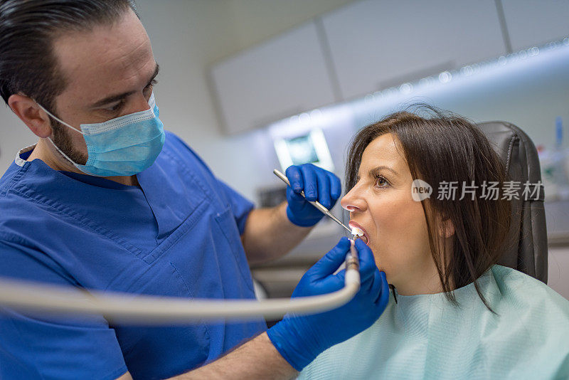 牙科医生戴上防护口罩和手套修复牙齿