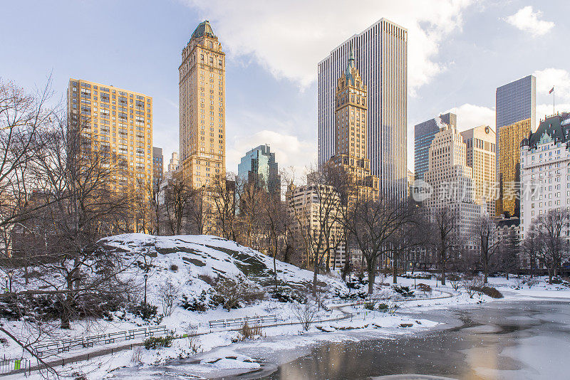 在美国纽约市曼哈顿市中心的冬天，从一个白雪覆盖的中央公园看到的城市景观。