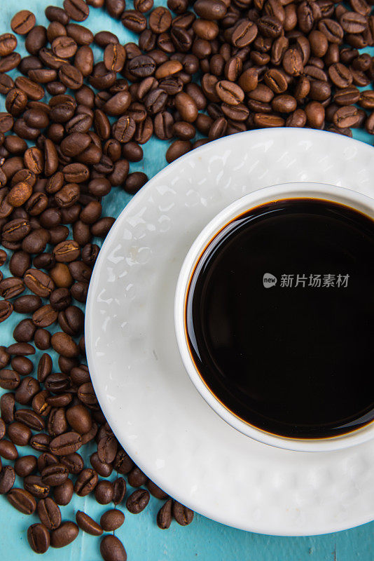 一杯黑咖啡和烘培咖啡豆在桌子上-顶端