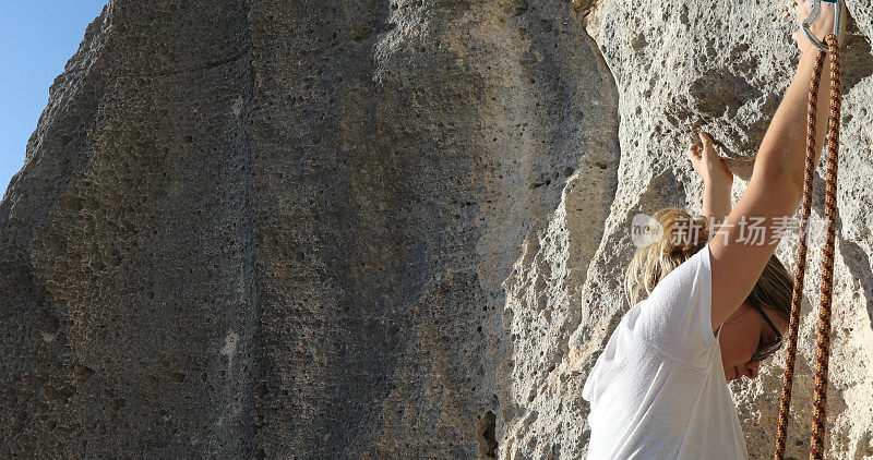 一名女性登山者正在攀登岩壁
