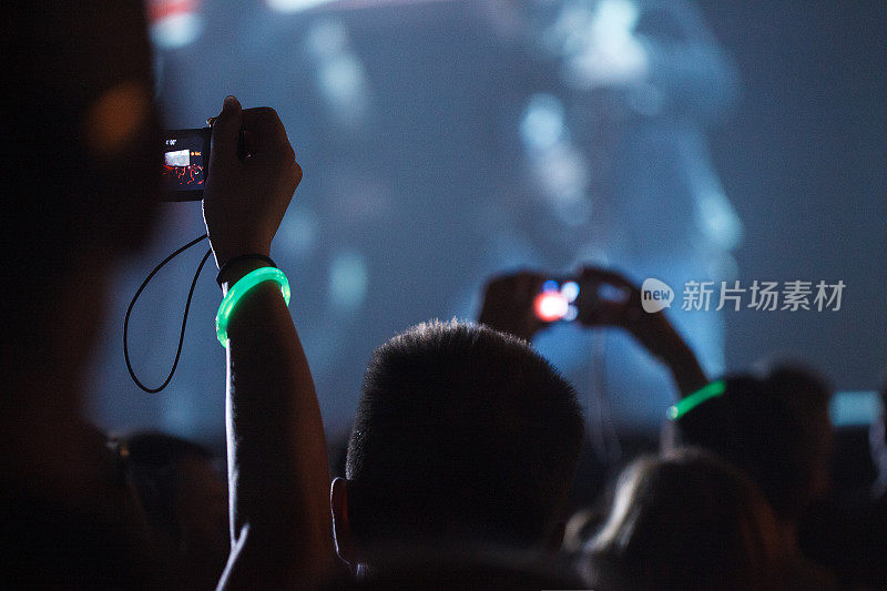 歌迷们在演唱会现场用智能手机拍照和录像