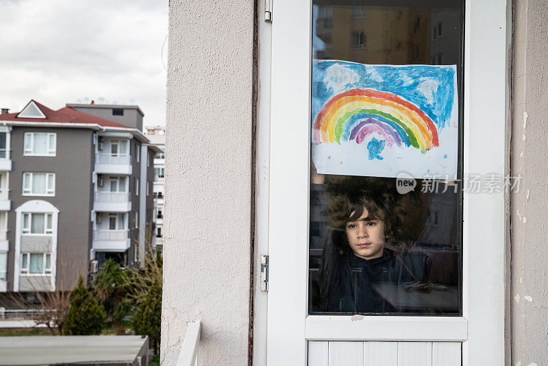 新冠肺炎隔离期间，一名学童透过窗户看东西