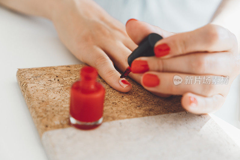 一个面目全非的女人用红色指甲油做指甲