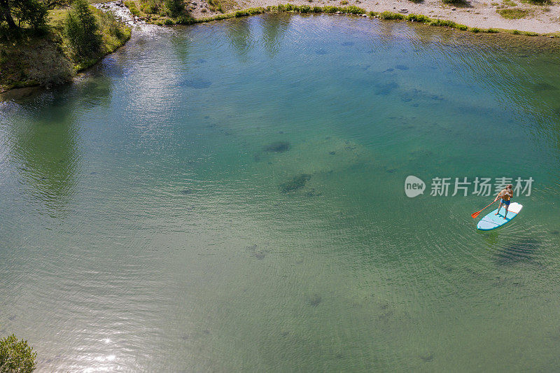 无人机上的女人在SUP山看冰川