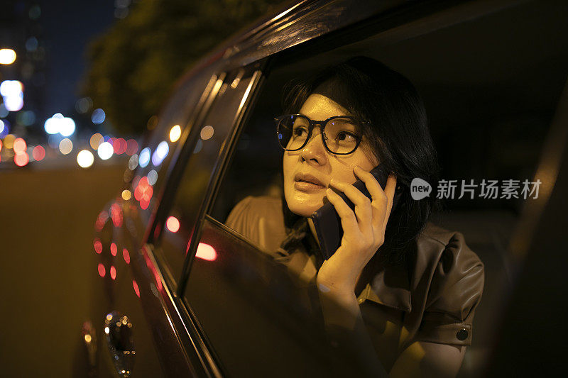 在车里拿着手机的亚洲女人