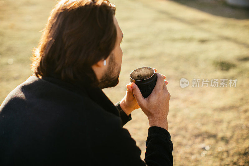 一个独自的旅行者在大自然中享受咖啡