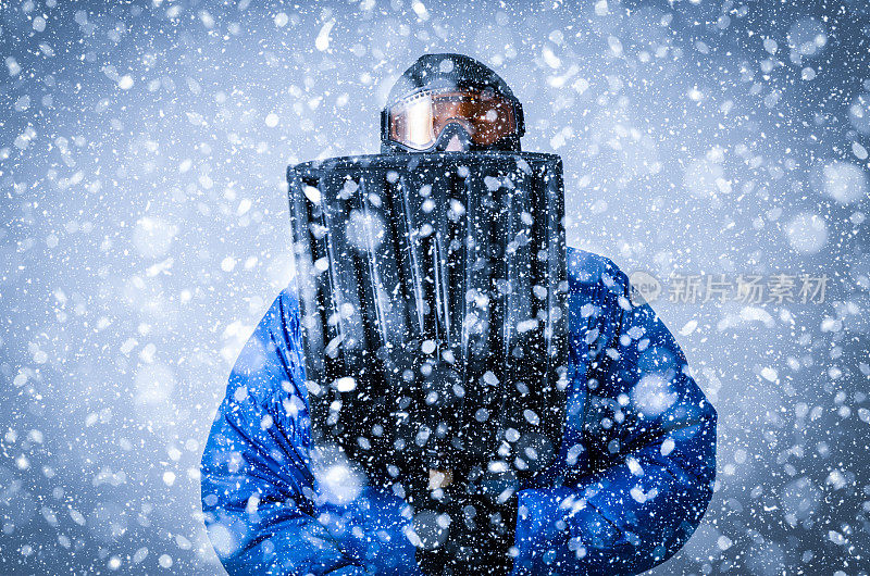 在暴风雪中戴着护目镜和铲子的人