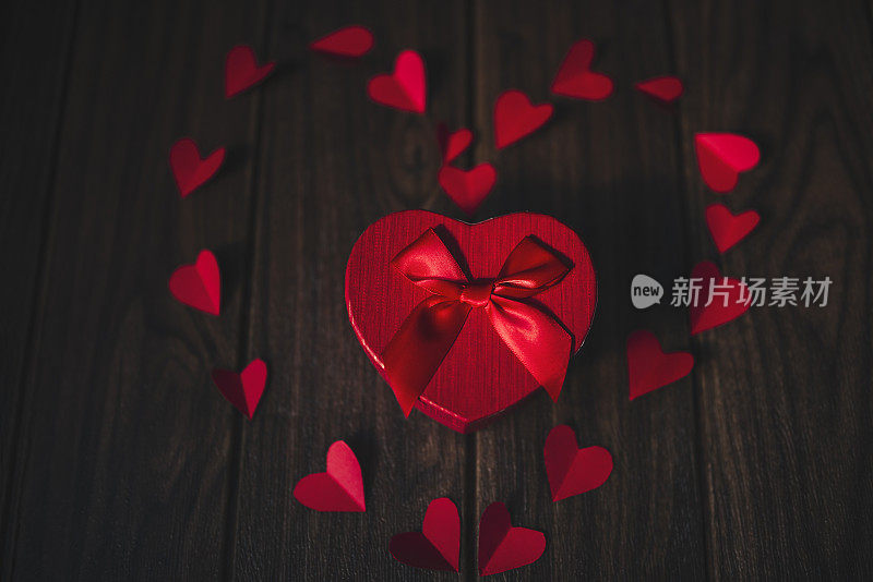 情人节礼物和红纸心形的黑木背景