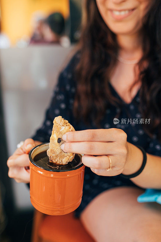 把饼干泡在咖啡里的女人