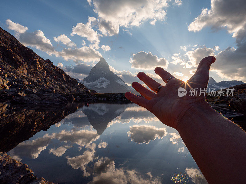 手触阳光的细节，马特洪峰山下的山湖