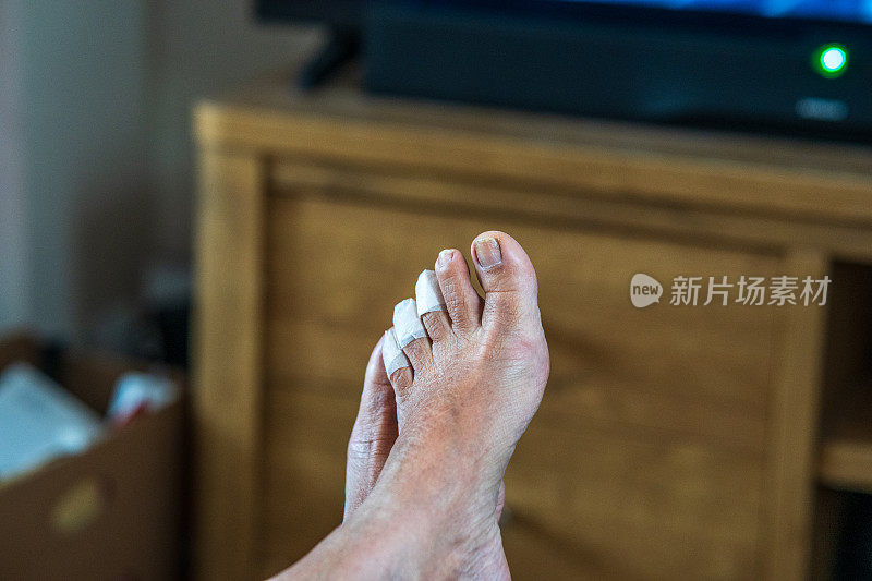 西班牙裔老妇人的脚，脚趾上有创可贴