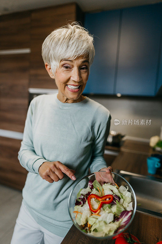 一位女士在厨房里用笔记本电脑打电话