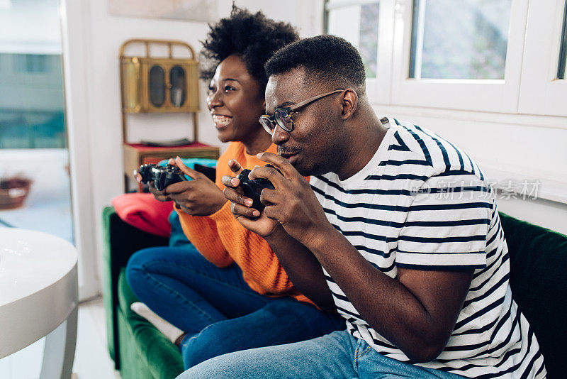 快乐的非洲裔美国夫妇在家里玩游戏