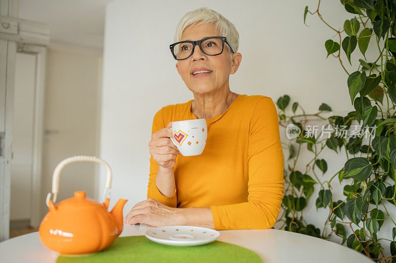 一位老妇人喝茶的照片