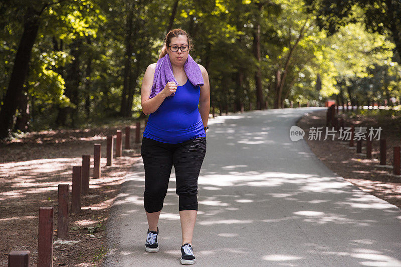 疲惫的女人在公园里快步走