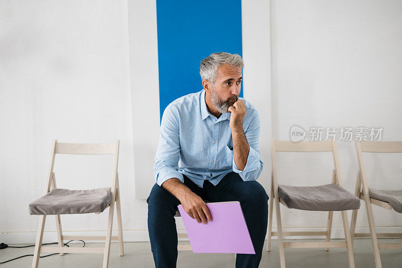 悲伤的商人申请新工作并等待，面试前的紧张是很正常的，焦虑的成熟男人在诊所等待他的体检