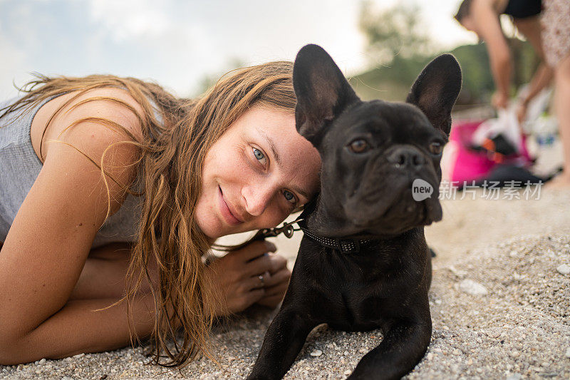 海滩上的女人和法国斗牛犬的肖像