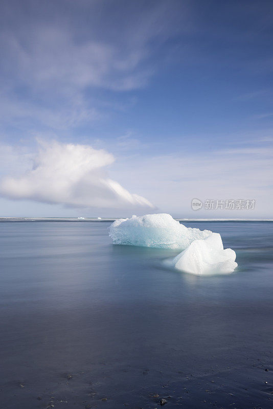 来自瓦特纳冰川的美丽的蓝色冰块被冲上了冰岛钻石海滩的黑色沙滩