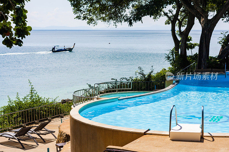 豪华热带别墅的游泳池，远处有游泳池和快艇。