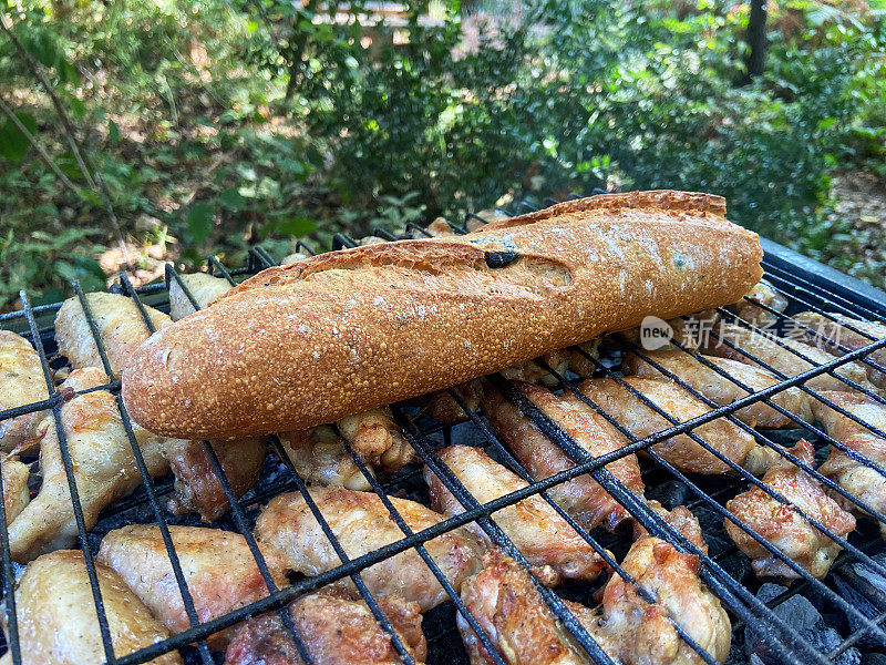 烤架上烤着鸡翅和面包