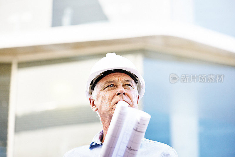 戴安全帽、拿着设计图的英俊中年男子:建筑老板、建筑师或土木工程师