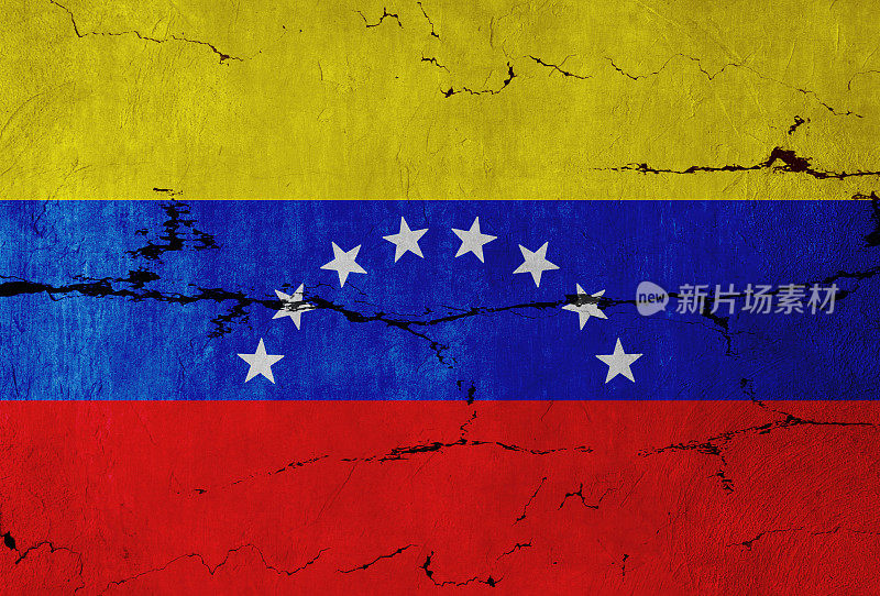 裂开的墙上挂着委内瑞拉国旗