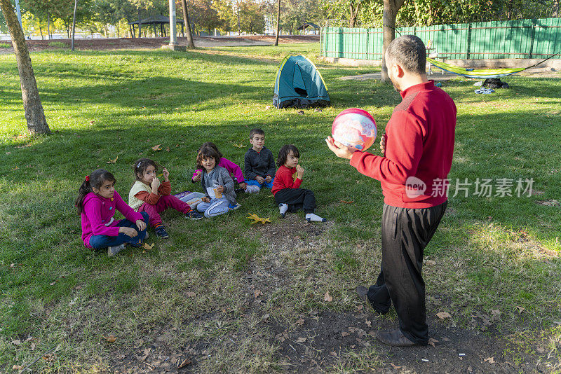 孩子们坐在草地上轮流讲故事，互相倾听