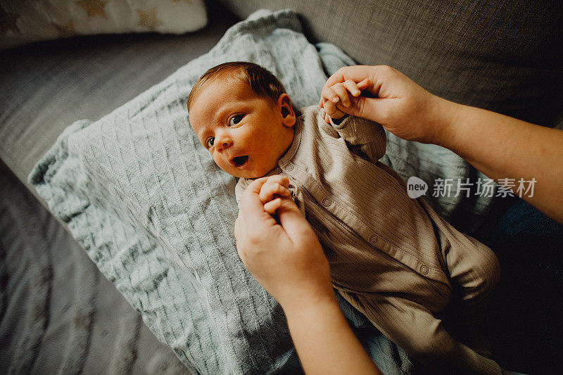 一个男婴躺在床上看着相机的高角度肖像