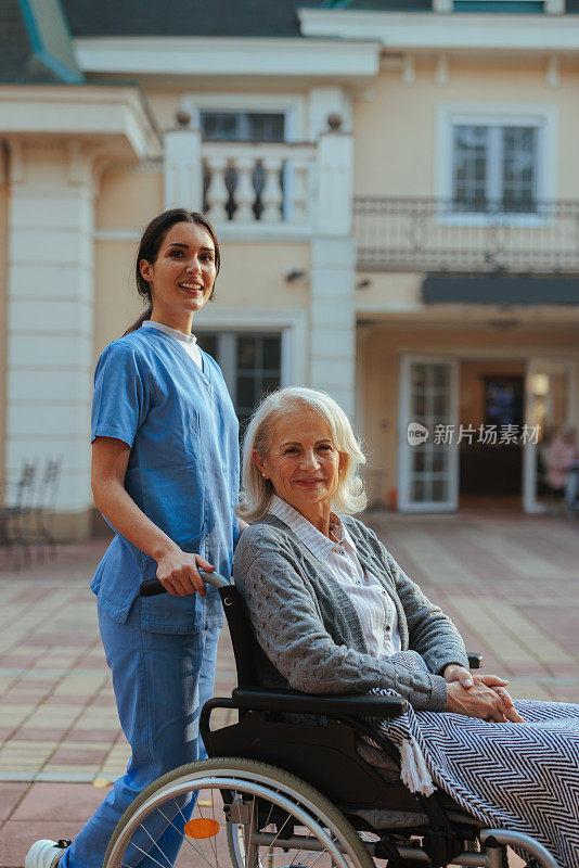 轮椅上的老年妇女和照顾者。