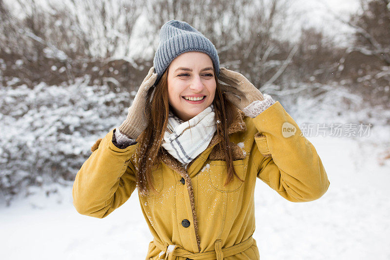 一个穿着黄色外套的漂亮女孩正期待着初雪的到来