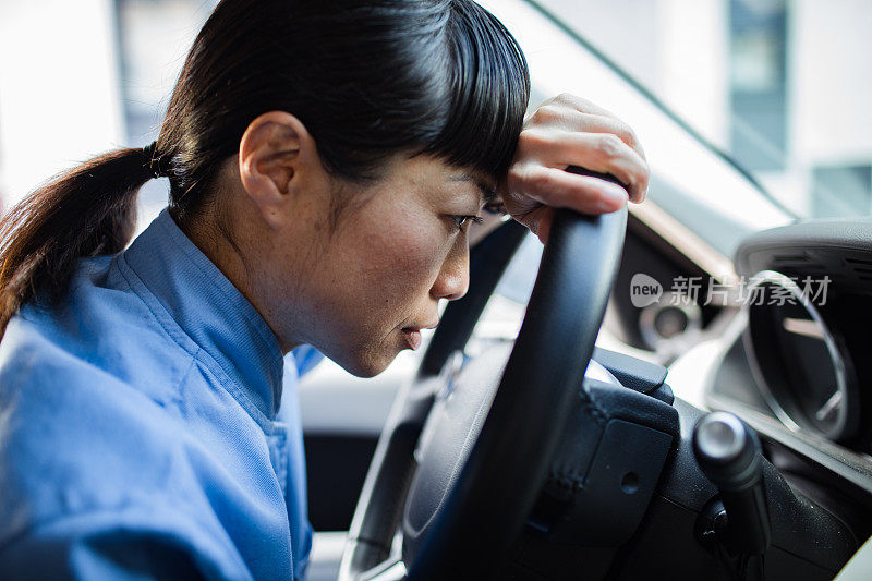 年轻的日本医护人员在车里感到疲惫和压力