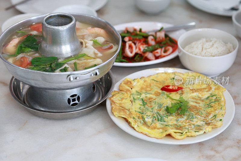 高角度观看正宗的泰国冬阴功美食，配以香喷喷的米饭、煎蛋和鱿鱼沙拉。